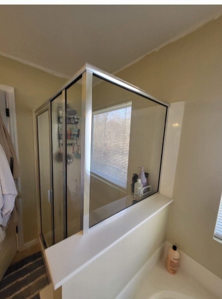 Remodeled bathroom with a framed glass shower enclosure