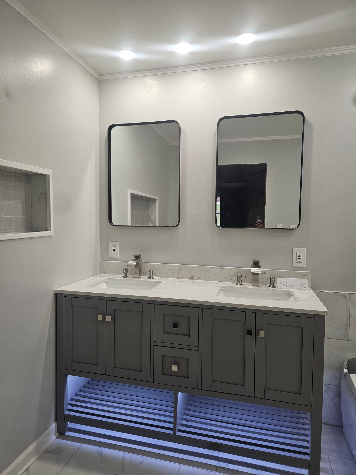 Gray double vanity with under-cabinet lighting in the same remodel