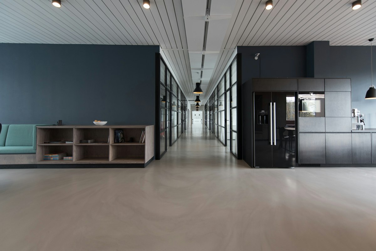 Open commercial interior with a kitchenette and glass offices