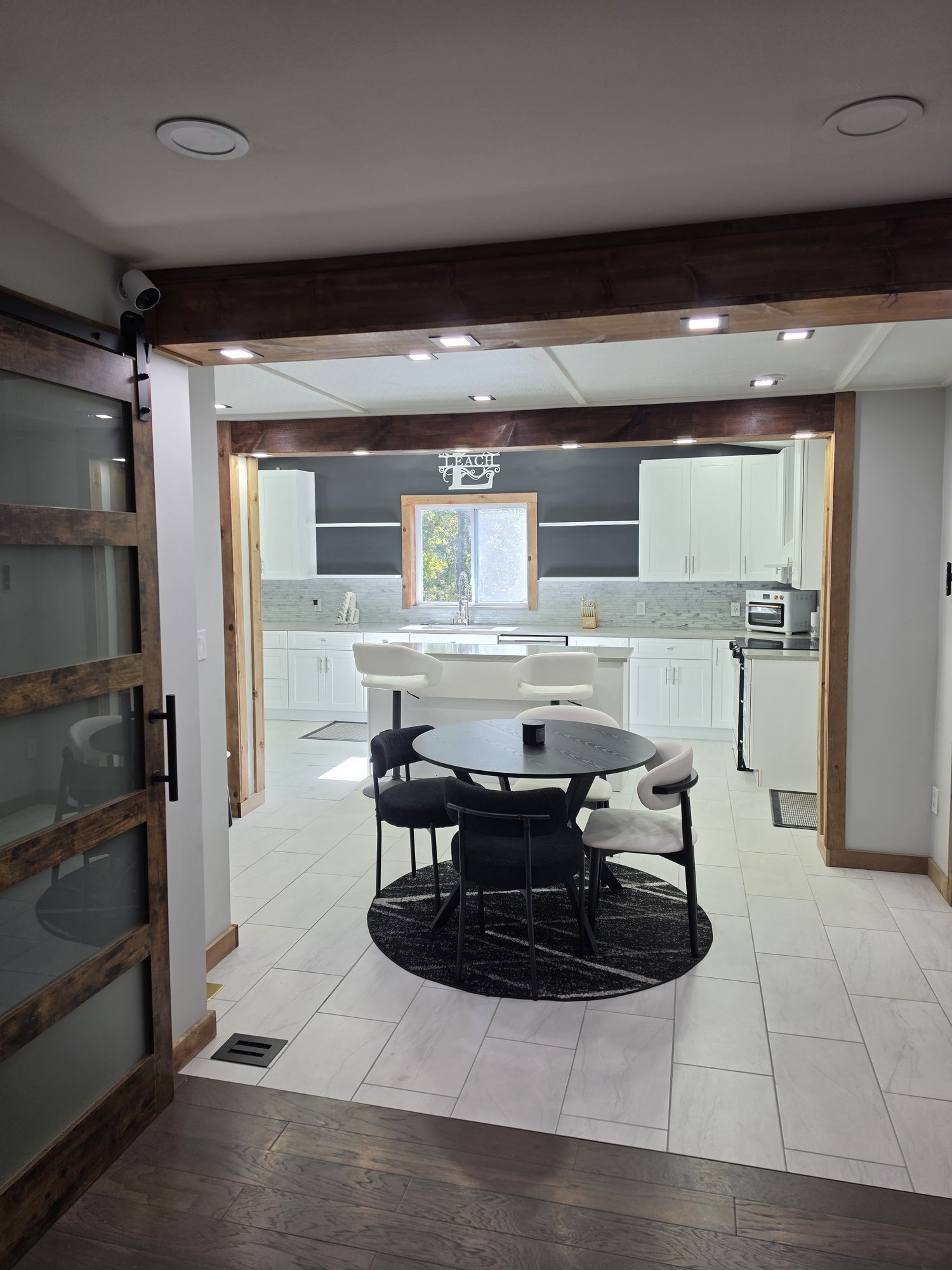Open kitchen and dining area seen through a sliding barn door