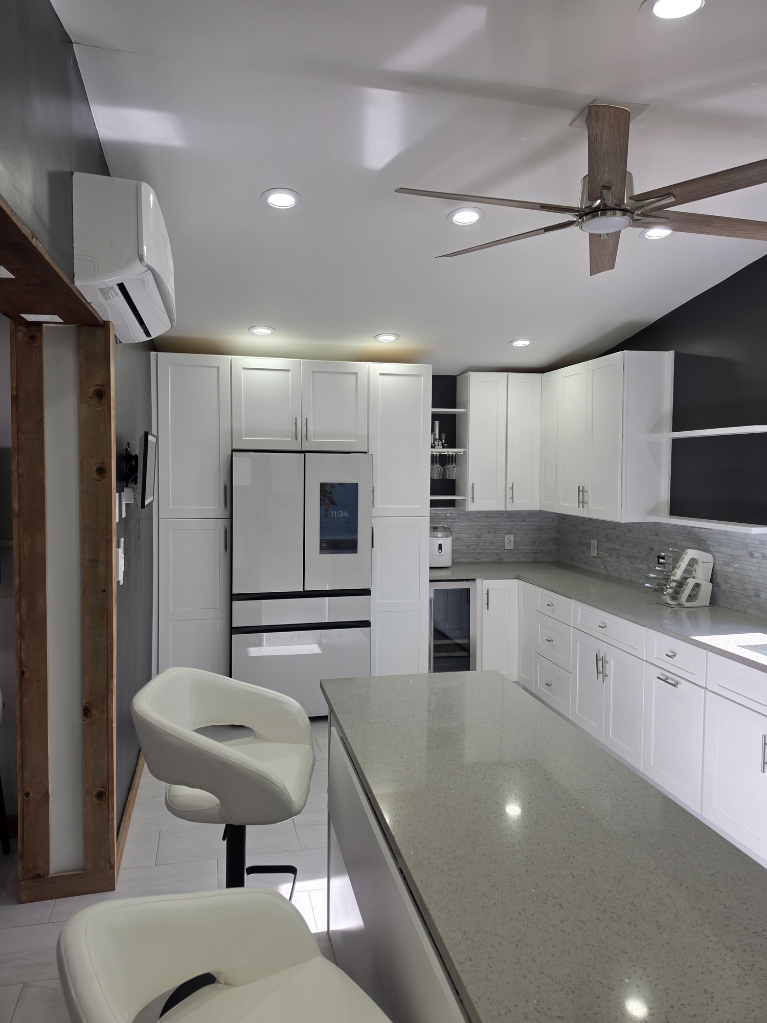 White shaker cabinets around a French-door refrigerator and wine fridge