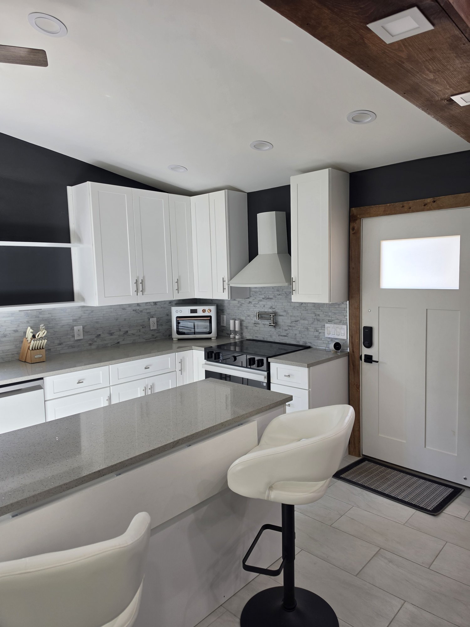 White range hood, open shelving and a side entry door