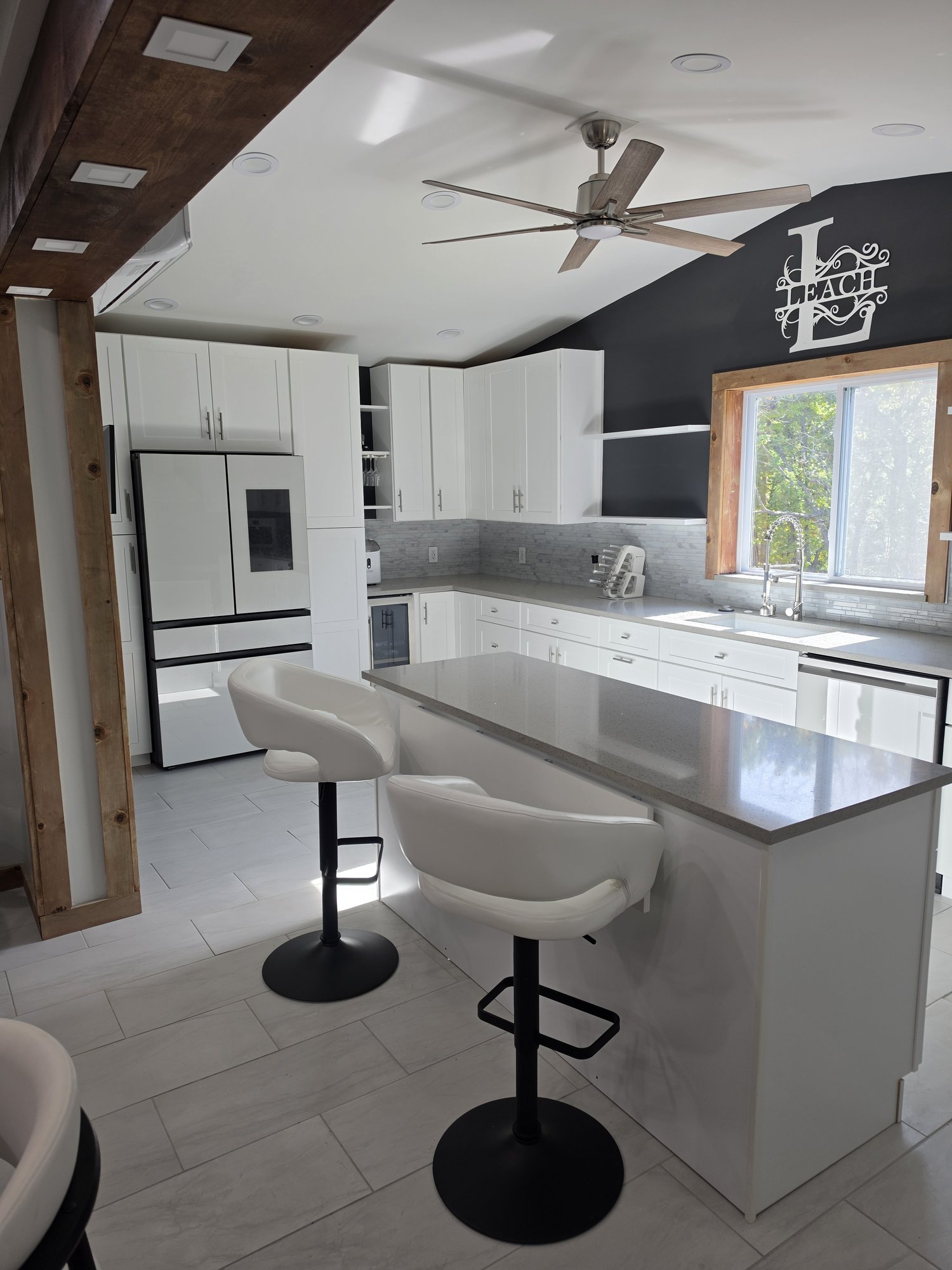 White kitchen with a gray quartz island and bar stools