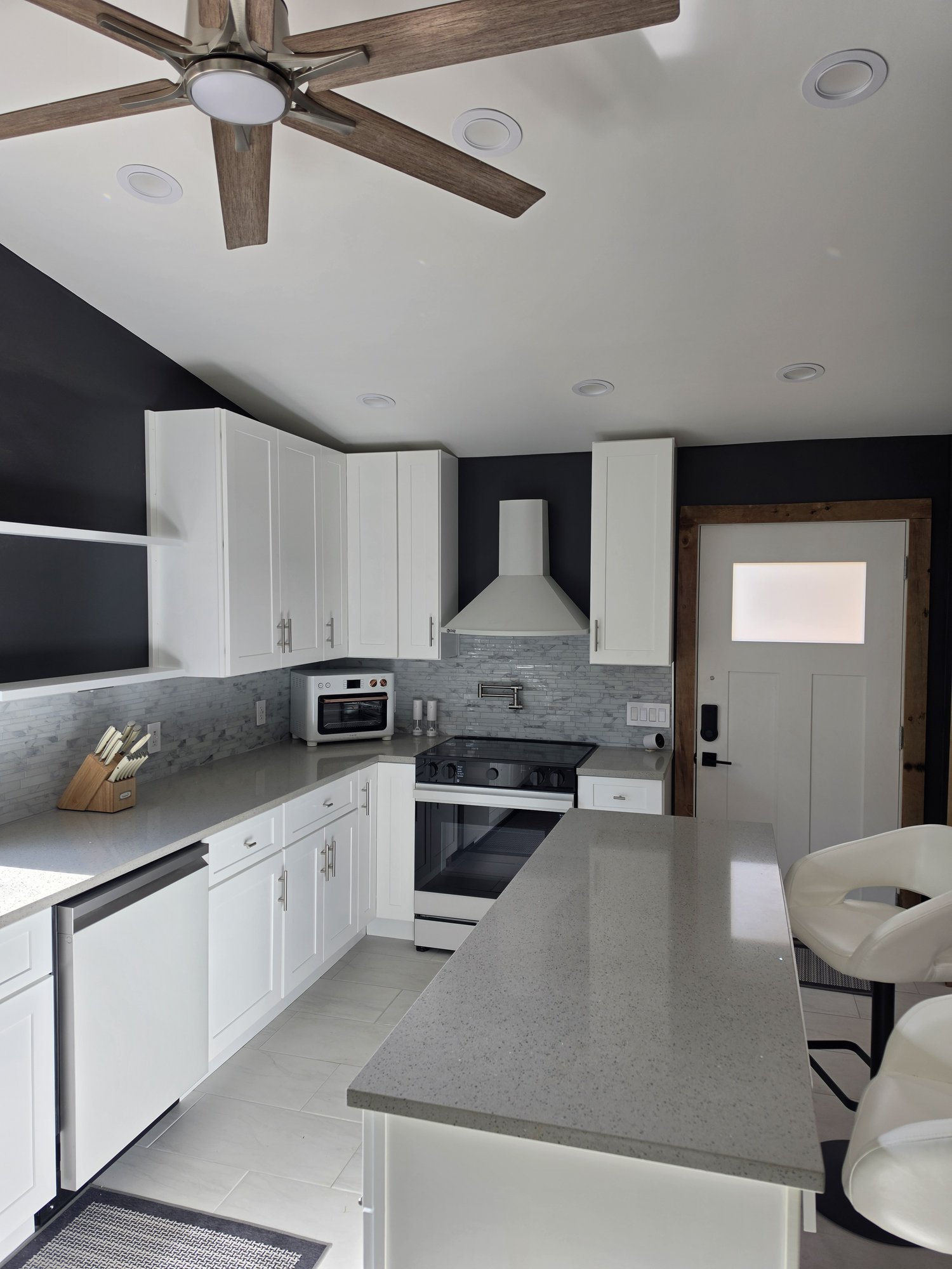 Range wall with a white hood and tile backsplash