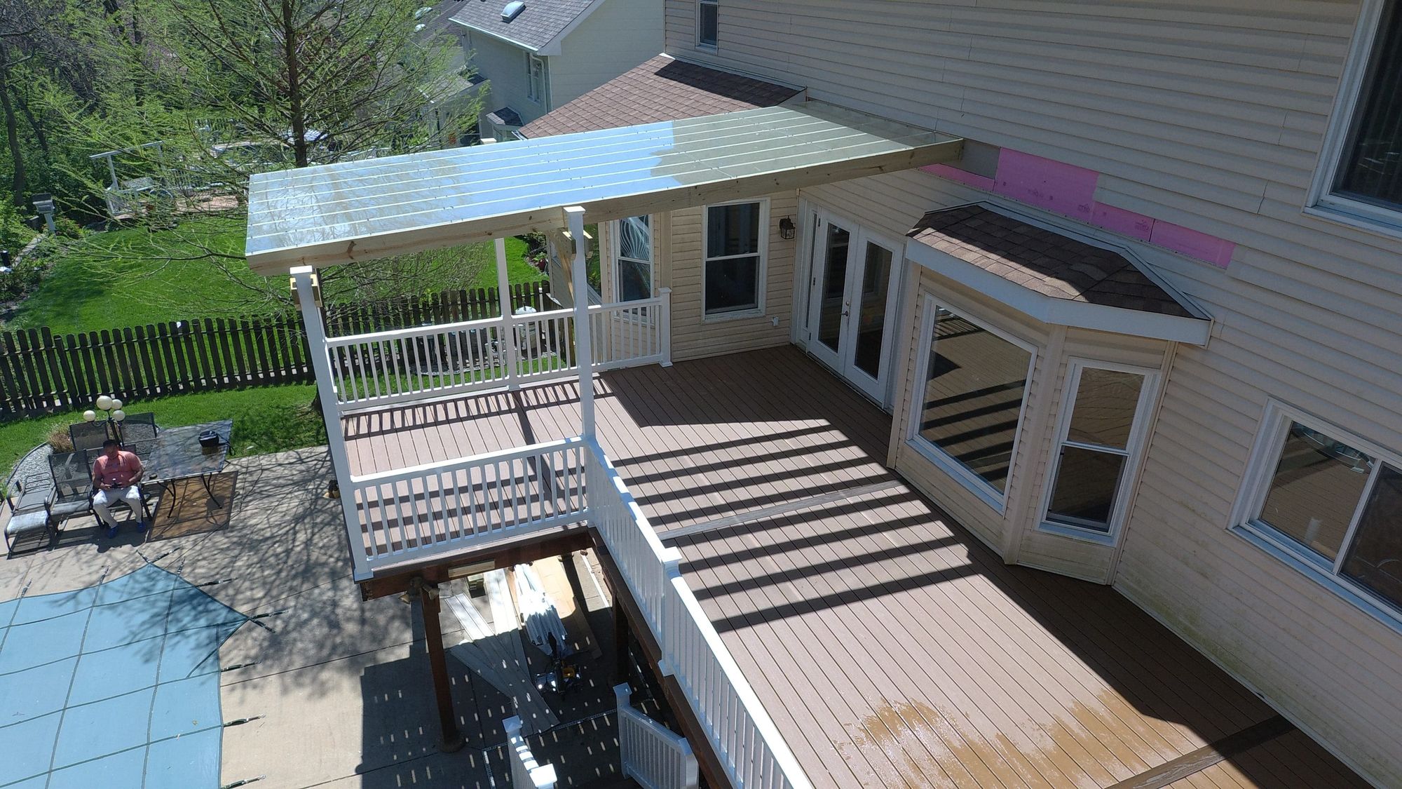 Deck with pergola overlooking an in-ground pool