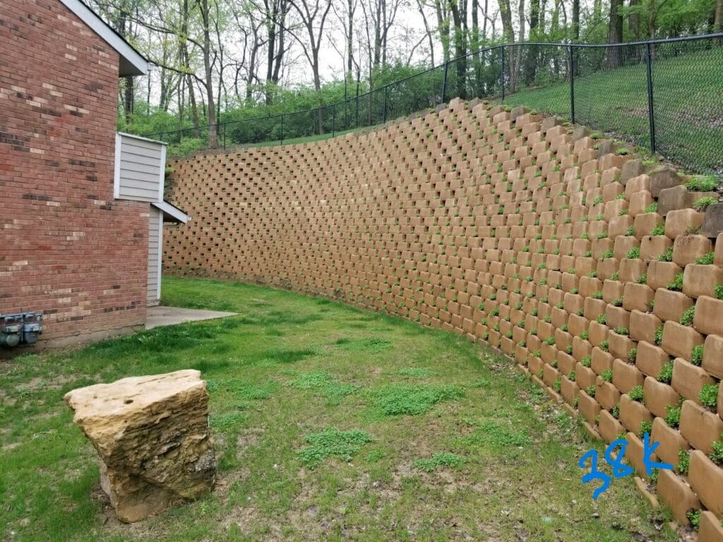 Curved block retaining wall beside a brick home